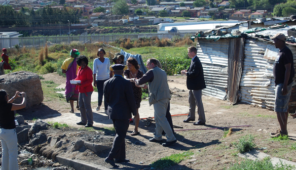 Jennifer stops to deliver food to families in the poor areas in Soweto during her trade mission to South Africa